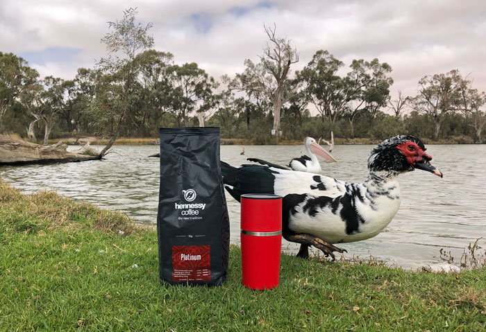The Cafflano coffee maker by the water, with a bag of coffee... and duck.