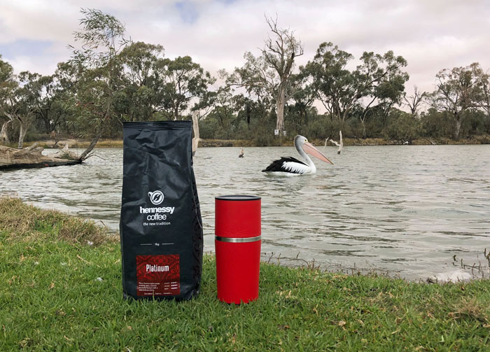 The Cafflano coffee maker by the water, with a bag of coffee.