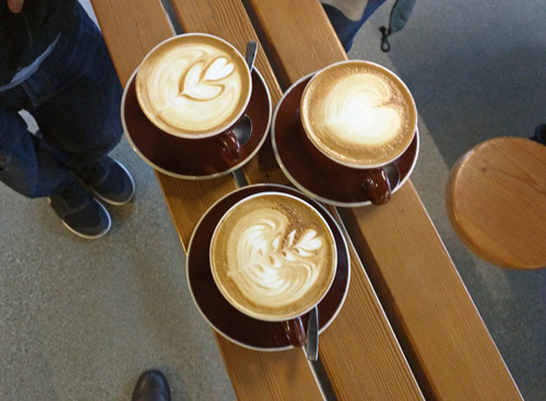 Three cafe lattes waiting to be enjoyed.
