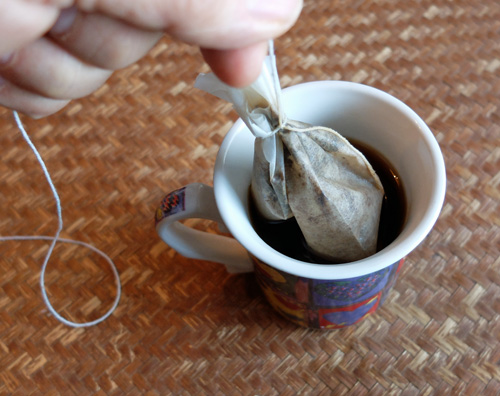 Making a coffee bag with a paper filter and string.