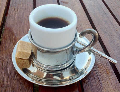 Silver coffee cup and spoon.